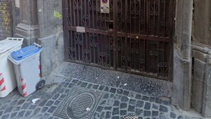 A large metal gate with intricate designs, a sign indicating a sale, and a trash bin on the ground. - Anima Partenopea (Naples)