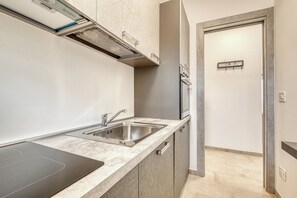 A modern kitchen with a stainless steel sink, a built-in oven, and a microwave. - Lanterne Luxury Apartments (Borghetto Santo Spirito)