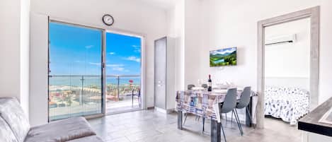 Een modern appartement met een balkon, een eethoek en een woongedeelte.