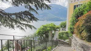 Una escalera que lleva a un balcón con vistas a un lago y montañas al fondo.