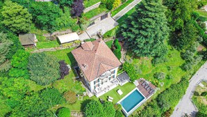 Vista aérea de una casa con techo de tejas, piscina y jardín cuidado.