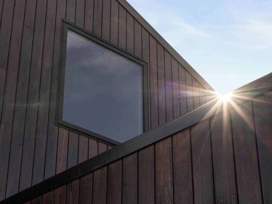 A modern building with a large window and a sloped roof.