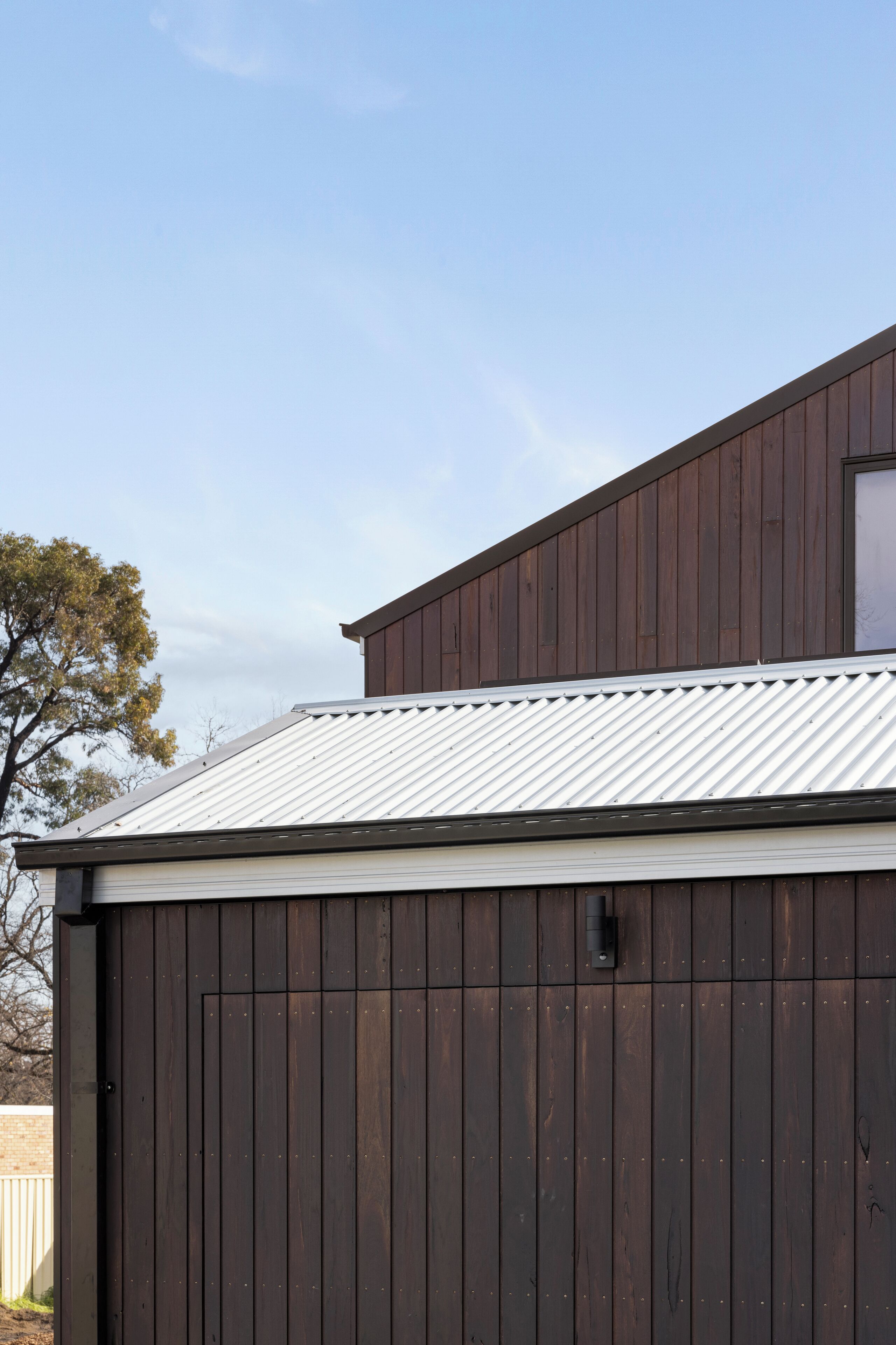 A building with a dark wooden exterior and a corrugated metal roof.