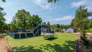 A playground with a climbing structure and a basketball hoop. - Nice Chalet in a Holiday Park (Arnhem)