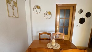 A dining room with a wooden table and chairs, a glass pitcher, and decorative wall art.