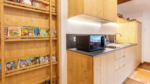 Une cuisine avec des meubles de rangement en bois, un four à micro-ondes et un évier.