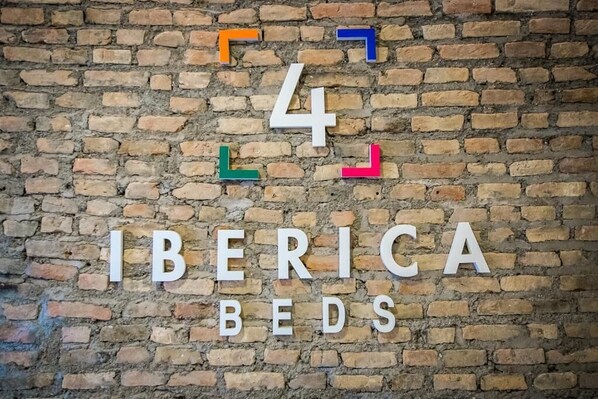 A brick wall with numbers and the text "IBERICA BEDS" indicating a hotel or accommodation. - Ibericabeds Granada (Granada)