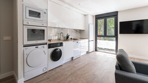 Une cuisine moderne dotée d’appareils électroménagers intégrés, d’un lave-vaisselle et d’une grande fenêtre qui laisse entrer la lumière naturelle.