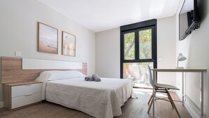 Une chambre à coucher comprenant un lit, une table de chevet, une chaise et un bureau avec une lampe.