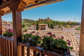 A balcony with wooden railings and potted plants.