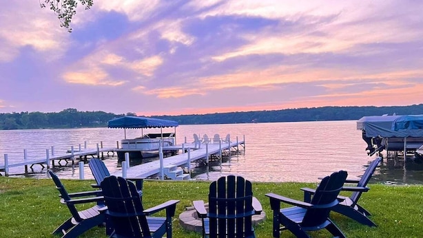 A lakeside view with chairs and a dock. - Shanahan Shores | Delavan Lakefront Cottage (Delavan)