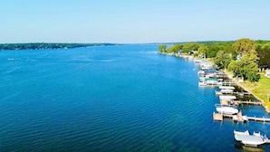 A marina with boats docked along a waterfront, surrounded by greenery and trees. - Shanahan Shores | Delavan Lakefront Cottage (Delavan)