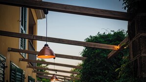 Una pérgola de madera con luces colgantes en un espacio al aire libre.
