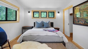 A bedroom with a large bed, a chair, a rug, and a painting on the wall. - Ranch Retreat a mile from Warm Springs Base Lodge; New home just under an acre (Ketchum)