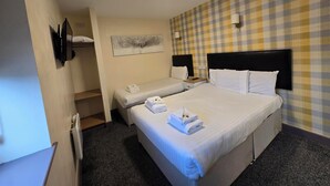 Habitación de hotel con dos camas, pared a cuadros, un cuadro y un televisor de pantalla plana.