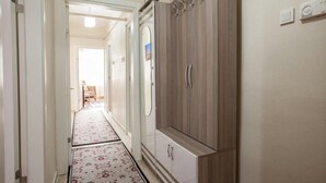 A hallway with a patterned rug, a wardrobe, and a door leading to another room. - Convenient 3-Bedroom flat for 10, Near Blue Mosque, AC & WiFi (Istanbul)