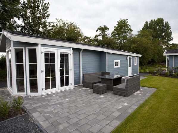 En moderne udendørs terrasse med integreret siddeområde og skydedør.