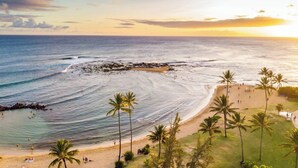 A beach with palm trees and a rocky shoreline. - 3BR Poipu Kai home 5 min walk to beach and pool summer deals (KOLOA)