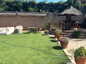 A backyard with artificial grass, a covered seating area, and potted plants. - Unterkunft Langzeitaufenthalte Wohngegend Guter Verkehrsanbindung 28km von BCN (Canovelles)
