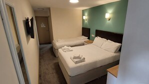 A hotel room with two beds, a flat-screen TV mounted on the wall, and a small wooden side table. - The Cotteridge Inn (Birmingham)