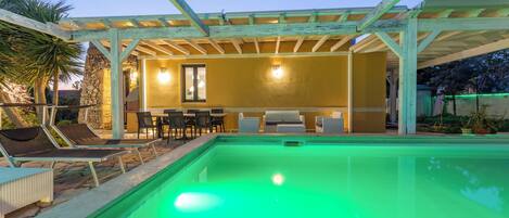 A pool area with lounge chairs and a covered patio.