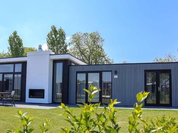 Situated in a peaceful suburban area, this two-story residence features large windows and doors, clean lines, and a minimalist design.