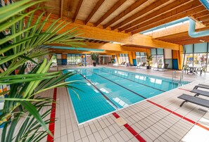 Relax by the pool surrounded by lush greenery and modern design elements.