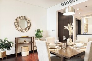 A dining area with a wooden table set for four, surrounded by chairs. - Anantara Palm Ocean View / Beach / Lagoon Pool (Dubai)