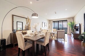 Un salon moderne avec un coin repas, de grandes fenêtres et une vue sur un pont.