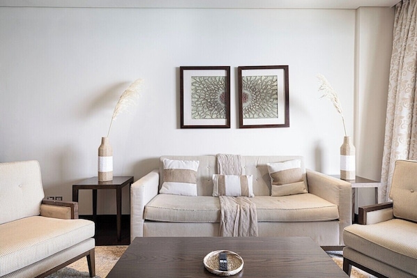 A living room with a sofa, two side tables, and a coffee table.