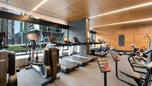 Un gimnasio moderno con cintas de correr, elípticas y pesas libres.