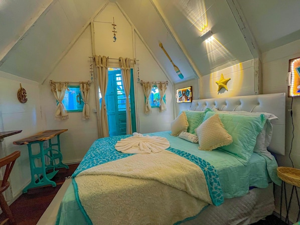 A cozy bedroom with a bed, a window, a star decoration, and a television.