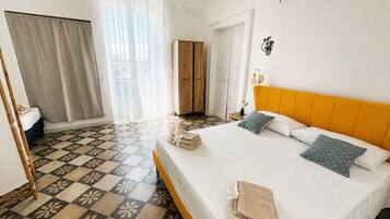 Una camera d'albergo con un letto, un armadio, un bagno e vista all'esterno.