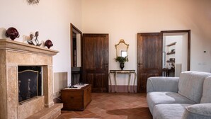 Una sala de estar con chimenea, un sofá y una puerta de madera.