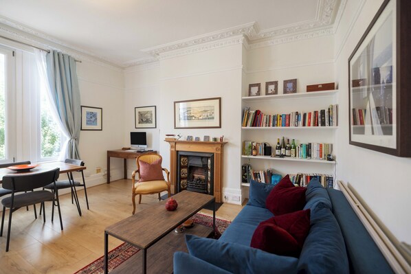 Cozy living room with a classic design, featuring a fireplace, dining area, and comfortable seating.