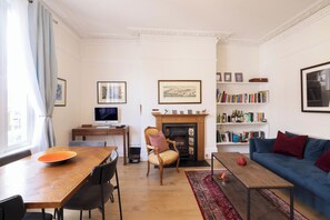 Relax in a traditional living room with a fireplace, comfortable sofa, and bookshelf.