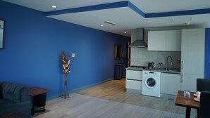 Una cocina moderna con armarios blancos, lavadora y comedor con mesa y sillas.