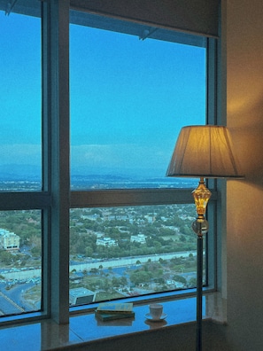 A room with a large window offering a view of a cityscape.