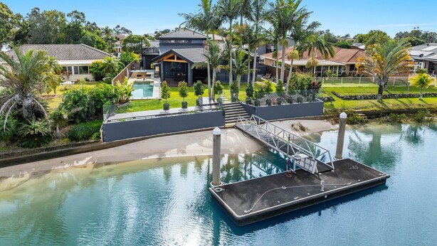 Un quartier résidentiel avec une piscine, un quai et des maisons en arrière-plan.