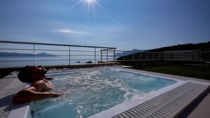 A pool area with a view of the sea and mountains.