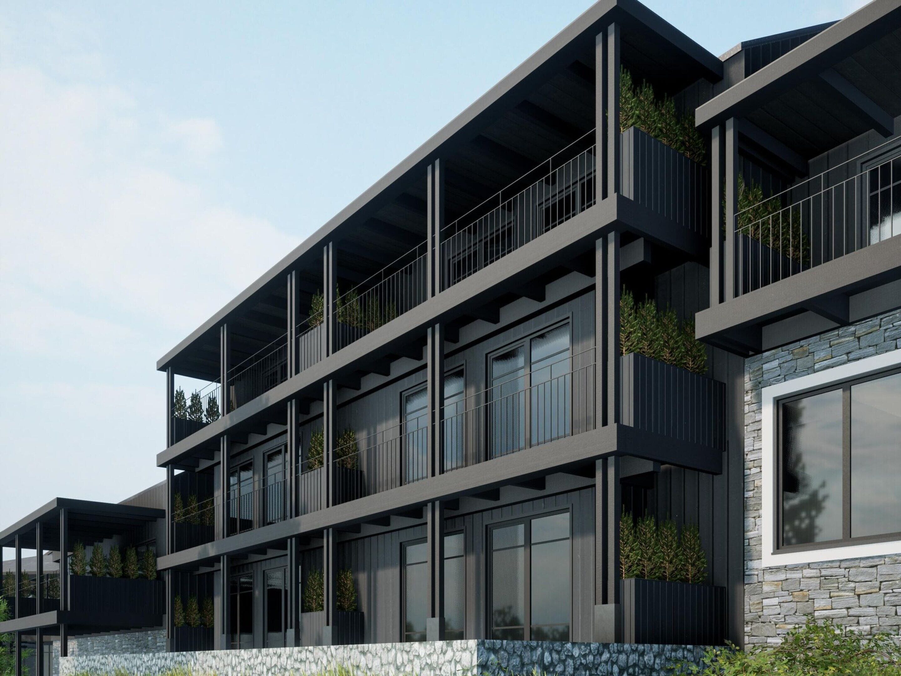 A multi-story building with balconies, large windows, and stone accents.