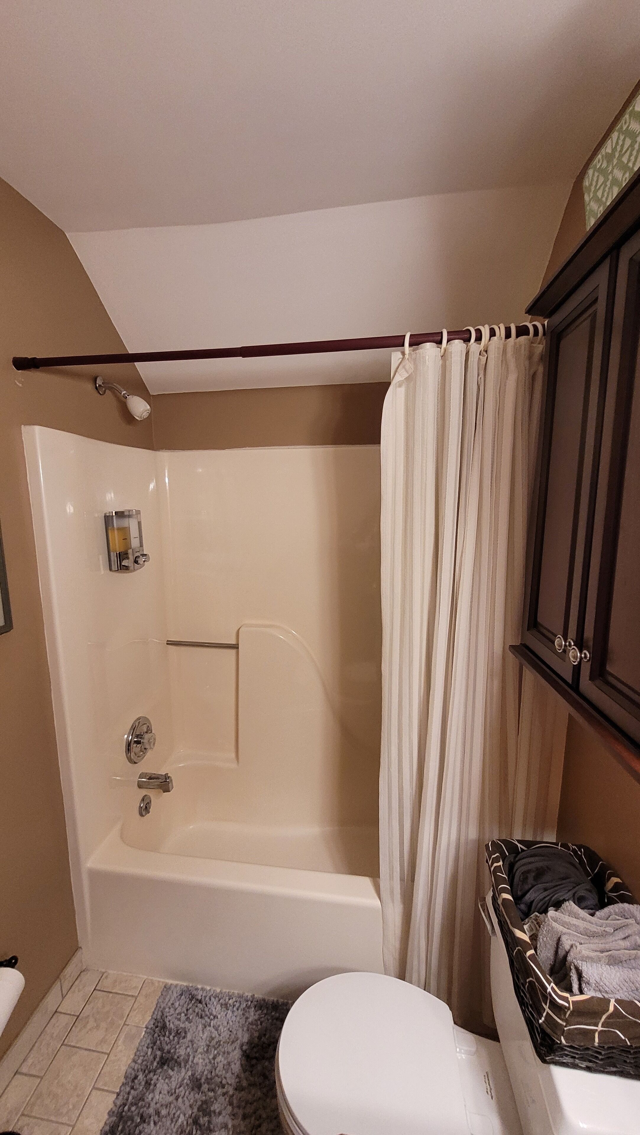 Un baño con bañera, inodoro y cortina de ducha.