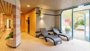 Un espace de détente avec un plancher en bois, un mur en briques et deux fauteuils.