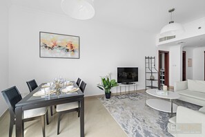 Ein modernes Wohnzimmer mit Essbereich, Fernseher und Sofa.