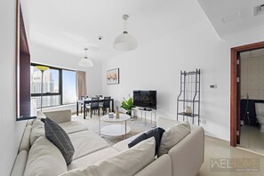 Exclusive Apartment, Balcony, Canal View | Living area | 49-inch Smart TV with cable channels - WelHome - Stunning High-Rise with Canal View Near MarinaMall (Dubai)