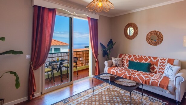 A living room with a sofa, coffee table, and a view of the outside. - GuestReady - Idyllic vacation with stunning views (Caniço)