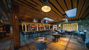 A restaurant with wooden floors, high ceilings, and a bar area. - Modern Chalet With Terrace Near Rockanje (Hellevoetsluis)