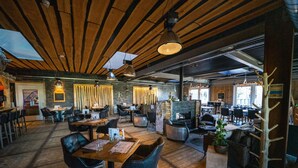 A restaurant with wooden floors, black leather chairs, and a mix of table and booth seating. - Modern Chalet With Terrace Near Rockanje (Hellevoetsluis)