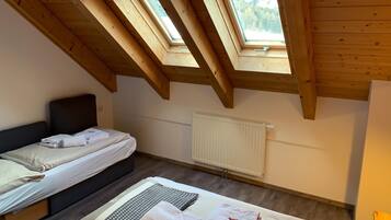 Una habitación con dos camas, una ventana y un radiador.
