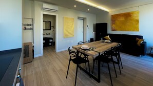 A modern living room with a wooden dining table, black chairs, a black sofa, and a large abstract painting on the wall. - Your home in Rome

4 Rooms & 4 Elements 

Spacious penthouse for 12 guests
 (Roma)